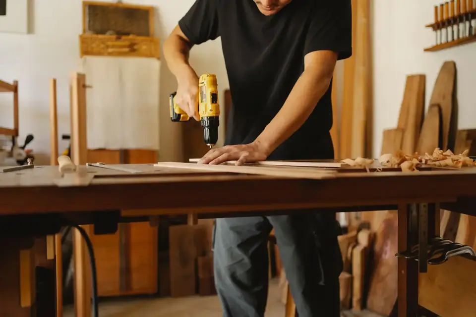 Vakman boort een gat in een plank