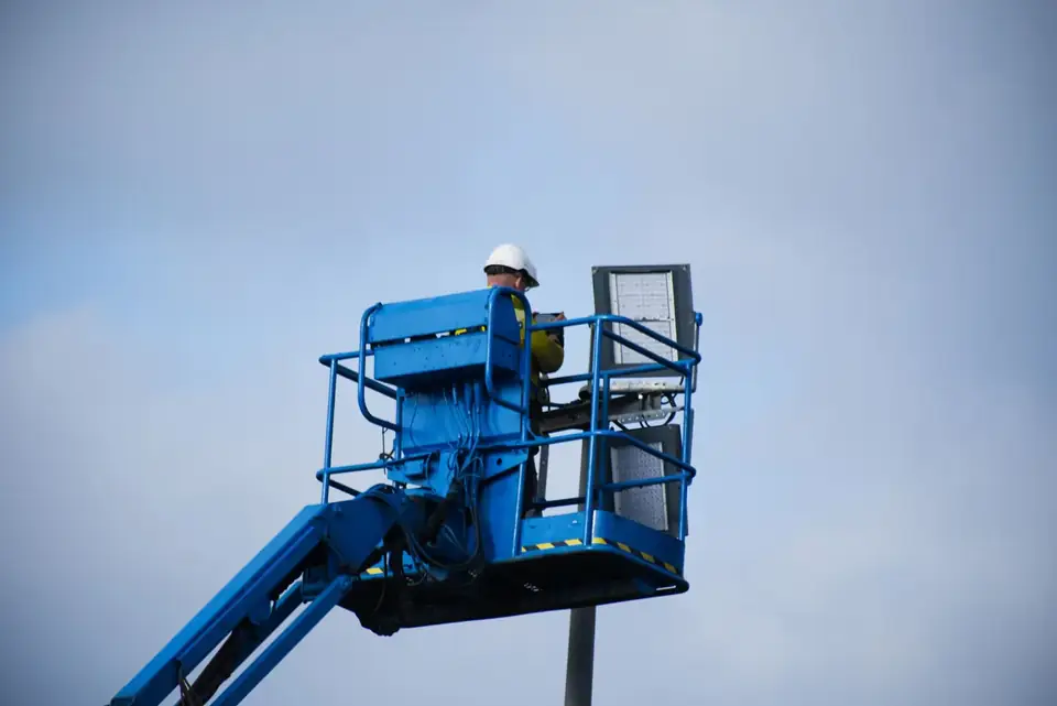 Monteur in de bak van een hoogwerker