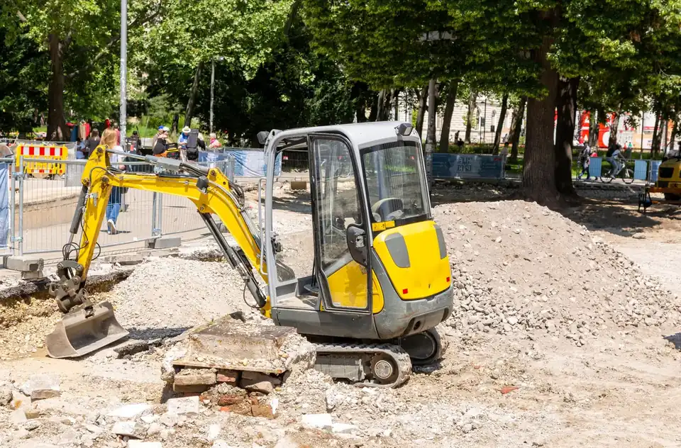 Gele minigraver bij straatwerk